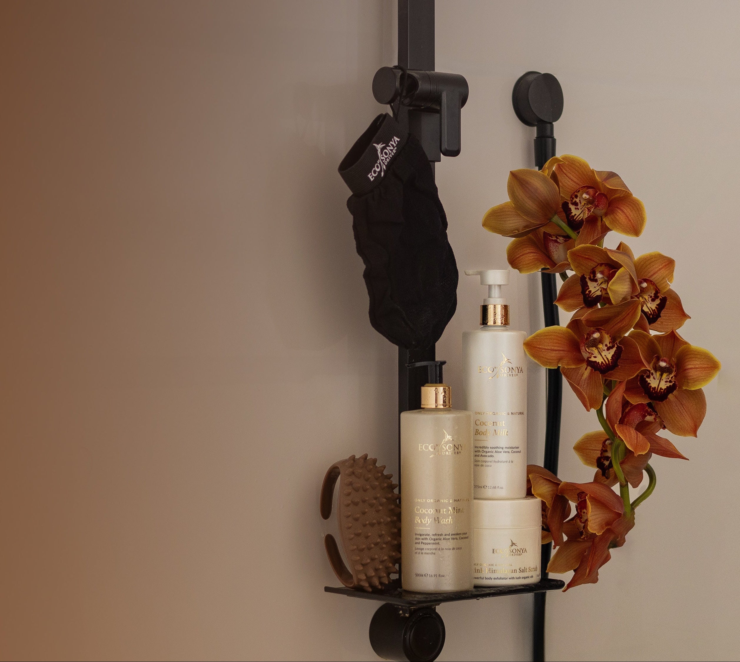 Bathroom shelf with Eco By Sonya Smooth Body Kit products and a decorative orchid on a neutral background