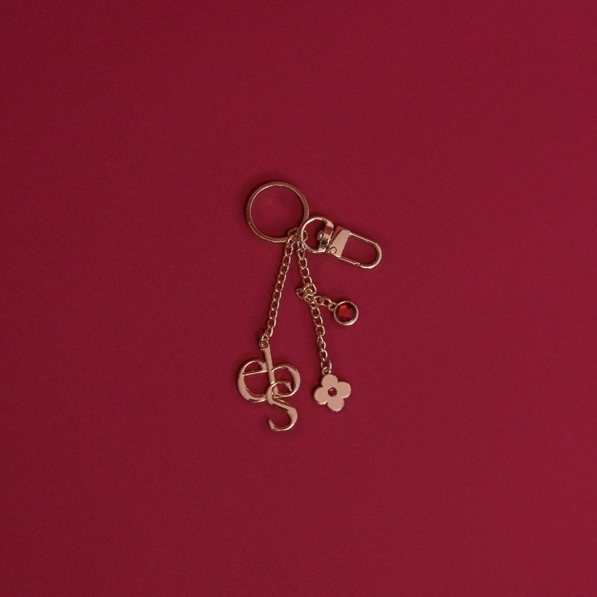 A gold charm on a deep red background.