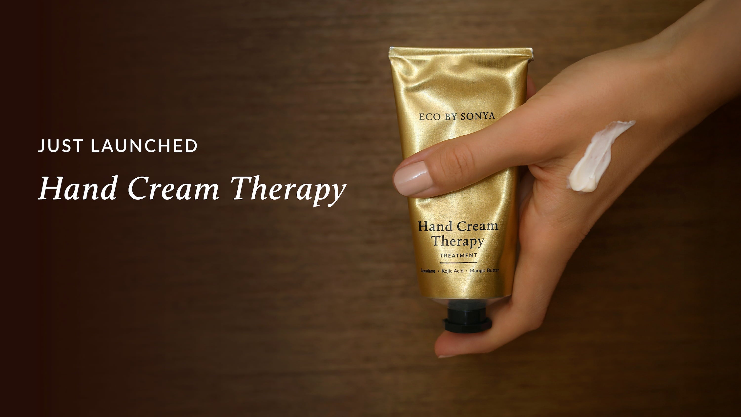 Hand holding Eco By Sonya Hand Cream Therapy Treatment with “Just Launched” text above.