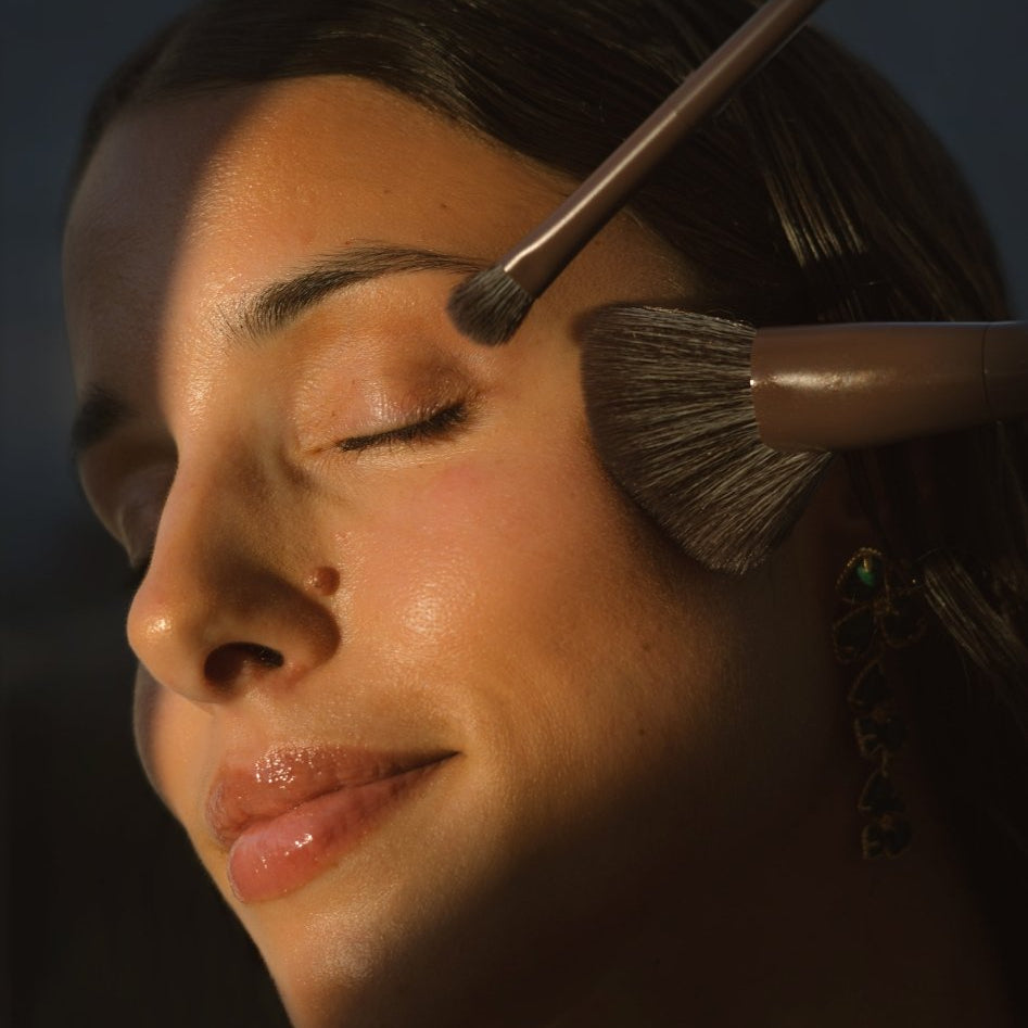 Close-up of a woman's face using 2 of the Eco By Sonya Makeup Brushes.