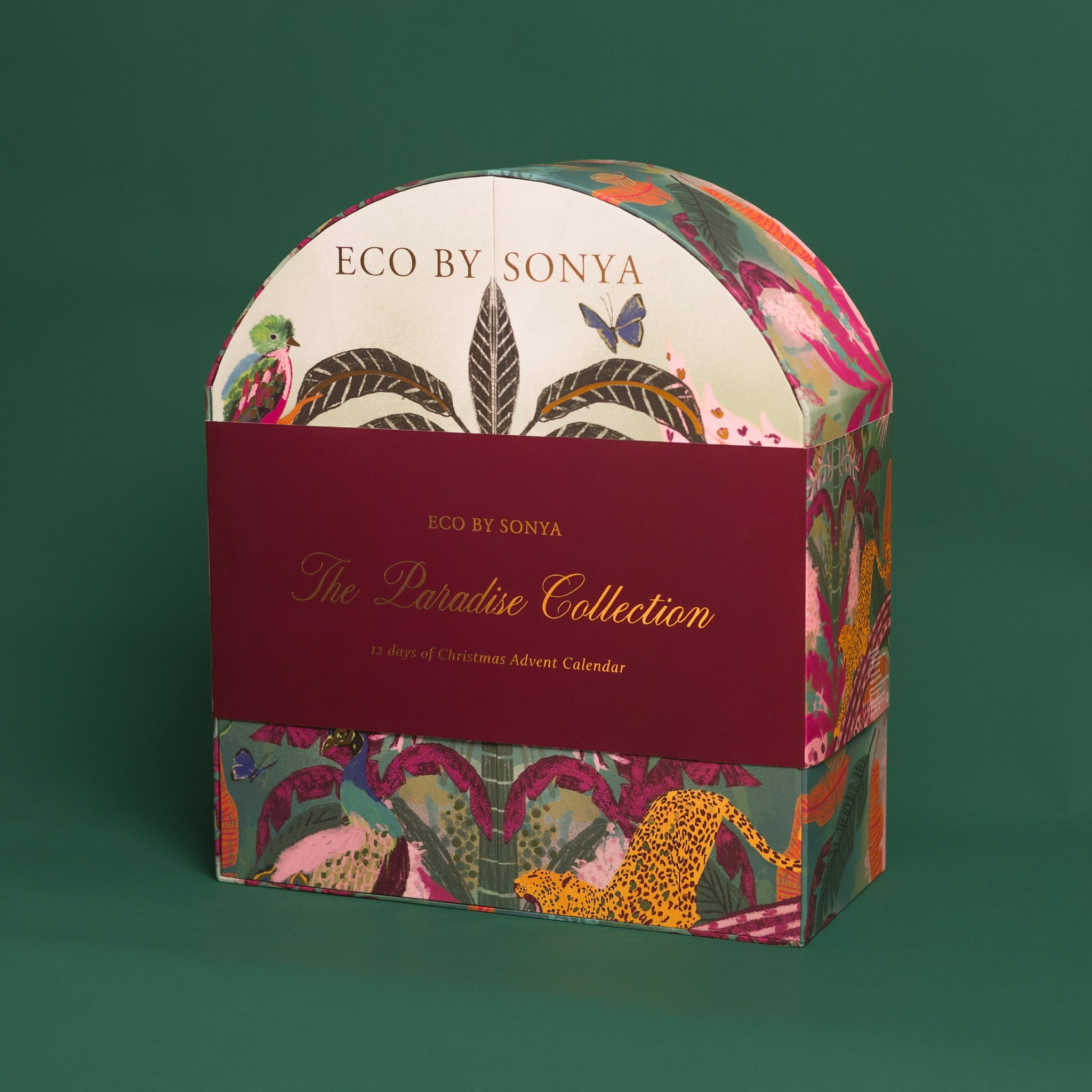 Eco By Sonya The Paradise Collection Christmas Advent Calendar box featuring a maroon sleeve with gold lettering and a colourful tropical jungle pattern on a dark green background.