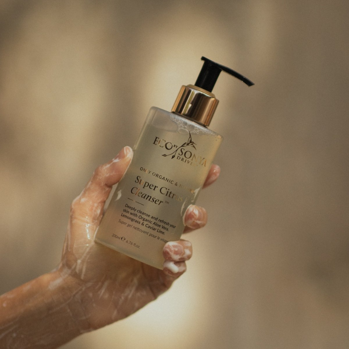 Hand holding organic Super Citrus Cleanser - Eco By Sonya