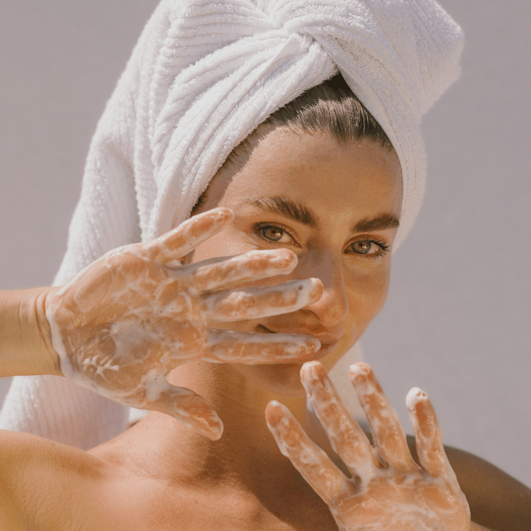 Woman with towel in hair using Super Citrus Cleanser, foamy hands - Eco By Sonya