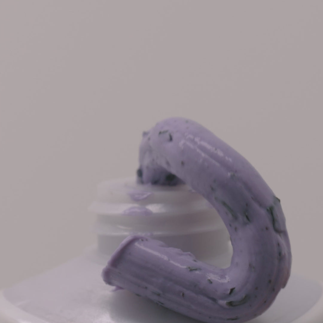 Applying Face Compost Purple Mask to face for detox treatment. Showing thick purple clay texture of Face Compost Purple Mask